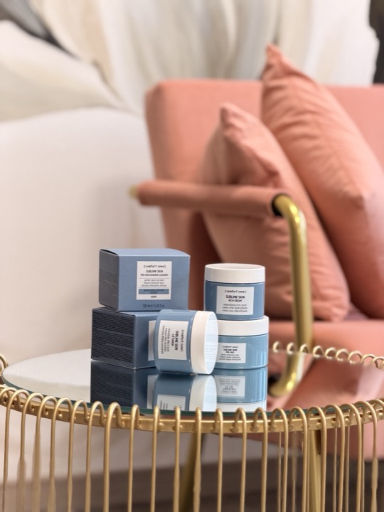 Poltrona rosa cipria e tavolino dorato con cosmetici mesoestetic